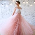 Bride in a tender light pink wedding dress in a morning