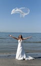 Bride throwing the veil near the sea