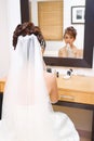 Bride to be applying make up in bedroom