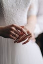 The bride touches the ring with her fingers. Hands in a white wedding dress with a gold wedding ring close-up Royalty Free Stock Photo