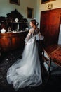 A bride in underwear and a white robe in the interior of a Villa in Italy at a wedding.morning of the bride in Tuscany.boudoir