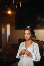 A bride in underwear and a white robe in the interior of a Villa in Italy at a wedding.morning of the bride in Tuscany.boudoir