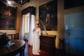 A bride in underwear and a white robe in the interior of a Villa in Italy at a wedding.morning of the bride in Tuscany.boudoir