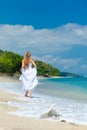 Bride walking along sea coast Royalty Free Stock Photo