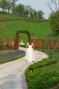 Bride walking in park with wooden gate Royalty Free Stock Photo
