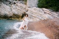 Bride walks on the beach holding the hem of the dress with her hands Royalty Free Stock Photo