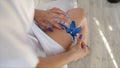 Bride wearing wedding garter. The bride wears a garter on the leg. Close-up of young bride putting on white grater Royalty Free Stock Photo