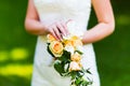 Bride wearing white dress holding wedding flowers outdoors Royalty Free Stock Photo