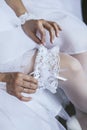 Bride is wearing a white lace garter on the wedding day Royalty Free Stock Photo