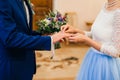 Bride wears gold ring on the groom`s finger at wedding Royalty Free Stock Photo