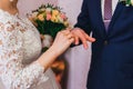 Bride wears a gold ring on groom`s finger at wedding ceremony Royalty Free Stock Photo