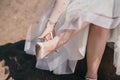 The bride wears shoes. The girl was tired of wearing shoes with heels. The woman takes her shoes off her feet. Royalty Free Stock Photo