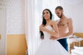 The bride wears a wedding dress in bedroom. Last preparations for the wedding. Wedding morning