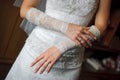 The bride wears wedding gloves. close-up of hands