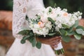 bride with wedding bouquet from orange and wite roses