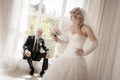 Bride with a wedding bouquet from roses and the groom sitting at a window Royalty Free Stock Photo