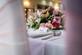 Bride wedding breakfast place setting with name card on top table waiting for arrival groom and pink roses and shiny glasses Royalty Free Stock Photo