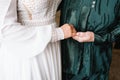 Bride on wedding day holding her mother& x27;s hands. an old woman holds her young daughter married Royalty Free Stock Photo