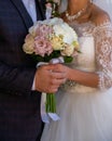 Bride in a wedding dress with a wedding bouquet holding hand with the groom Royalty Free Stock Photo