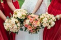 bride in wedding dress and bridesmaids red dressing holding Wedding bouquets on ceremony