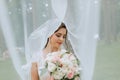 the bride in a wedding dress with a long train and a veil holds a wedding bouquet Royalty Free Stock Photo