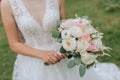 the bride in a wedding dress with a long train and a veil holds a wedding bouquet Royalty Free Stock Photo