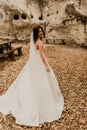 bride in wedding dress run away through autumn forest on fallen orange leaves to mountain Royalty Free Stock Photo