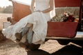 Bride in wedding dress sitting in red truck& x27;s truck in cowboy boots