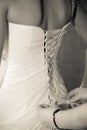 Bride in wedding gown doing the laces on the back. Royalty Free Stock Photo