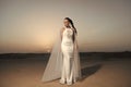 Bride in wedding gown on sunset sky. Woman in white dress in desert. Sensual woman with brunette hair. Fashion model in Royalty Free Stock Photo