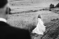 Bride whirls on the field road and looks at a groom