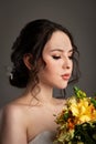 Bride in white dress with bouquet in photostudio