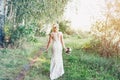 Bride in white dress with a bouquet is walking along. Royalty Free Stock Photo