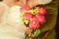 The bride in a white dress with a bright wedding bouquet of pink peonies in her hands Royalty Free Stock Photo