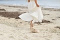 Bride in white dress and golden shoes on the beach Royalty Free Stock Photo
