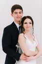 The bride in a white dress and groom in a blue suit are standing in the room and holding a wedding bouquet. Close-up portrait. Hap Royalty Free Stock Photo