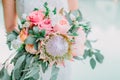 Bride in white dress and hold a wedding pink bouquet with proteus. Wedding day