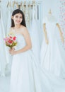 Bride in white dress holding a bouquet on hand for wedding,Beautiful asian woman smiling and happy,Romantic and sweet moment