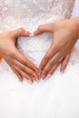 The bride in white dress holding hands in a heart shape. Royalty Free Stock Photo