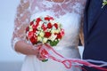 Bride in white dress holding a wedding colorful rose bouquet in her hand Royalty Free Stock Photo