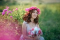 A bride in a white dress holds a bouquet of roses and callas on the background of green grass. Royalty Free Stock Photo