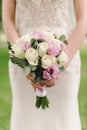 the bride in a white dress holds a wedding bouquet in her hands Royalty Free Stock Photo