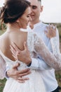 Bride in white dress stands with her back, her groom hugs her Royalty Free Stock Photo