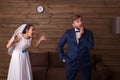 Bride in white dress and veil shouting at groom