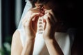 The bride in a white dress wears gold earrings with pearls. Royalty Free Stock Photo