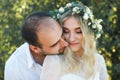 Bride in white dress and wreath and groom portrait in sunny summer day. Rustic outdoor wedding concept Royalty Free Stock Photo