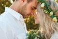 Bride in white dress and wreath and groom portrait in sunny summer day. Rustic outdoor wedding concept Royalty Free Stock Photo