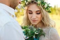 Bride in white dress and wreath and groom portrait in sunny summer day. Rustic outdoor wedding concept Royalty Free Stock Photo