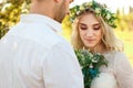 Bride in white dress and wreath and groom portrait in sunny summer day. Rustic outdoor wedding concept Royalty Free Stock Photo