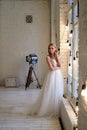 The bride in a white lace dress with embroidered bodice, indoors in loft style. Long,flowing, ash-colored hair. Royalty Free Stock Photo
